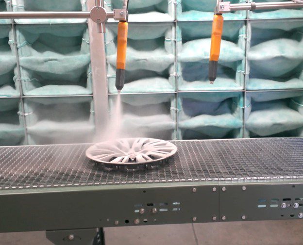 injection-molded plastic object on a conveyor and being coated with an electrostatic powder gun